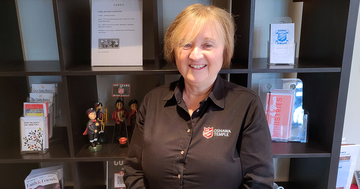 A smiling woman in front of a book shelf